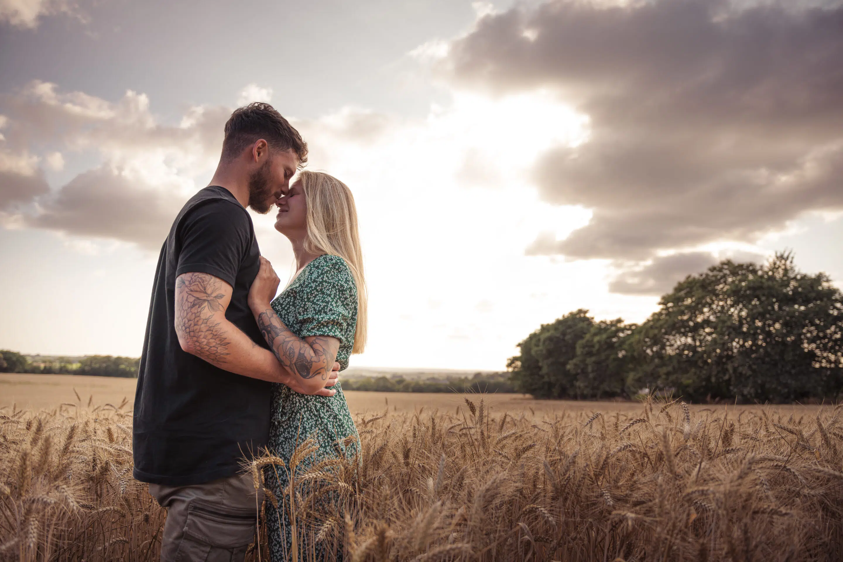 Photo couple dans un champs de blé sous un coucher de soleil fait par julien marino photographe
